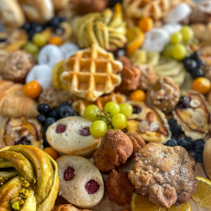AM Board featuring assorted seasonal baked goods, fruit, and pastries close-up view
