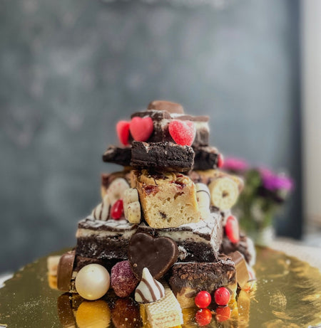 Valentine’s Day Brownie Tower with layered brownies, candy, and cookies decorated with heart-shaped treats